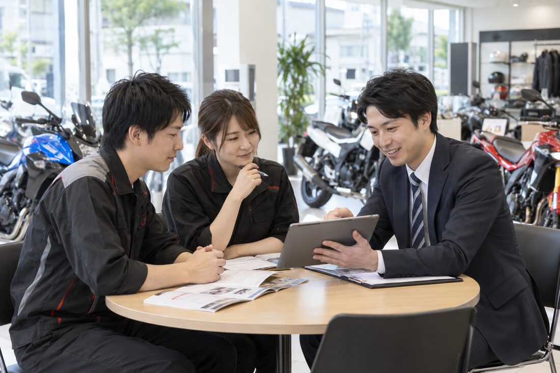 販売店の現場でTMRSスタッフが店舗スタッフを指導するイメージ